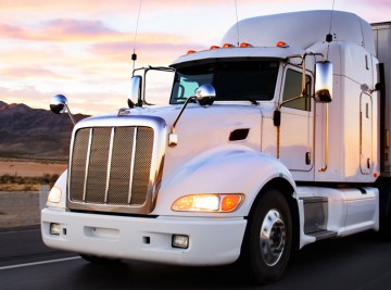 A closeup look of the white truck on the road during a sunset